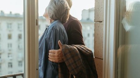 Couple mature complice près d'une fenêtre